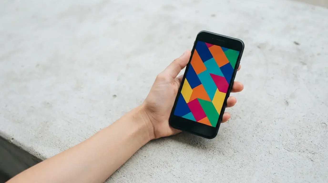 Hand holding smartphone with abstract tiles on the screen